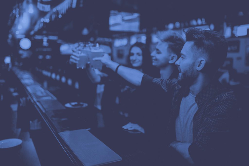 People clinking glasses in sports bar