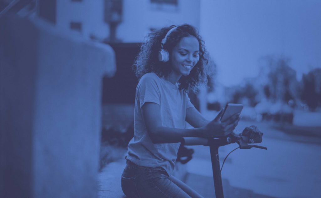 woman with headphones on scooter