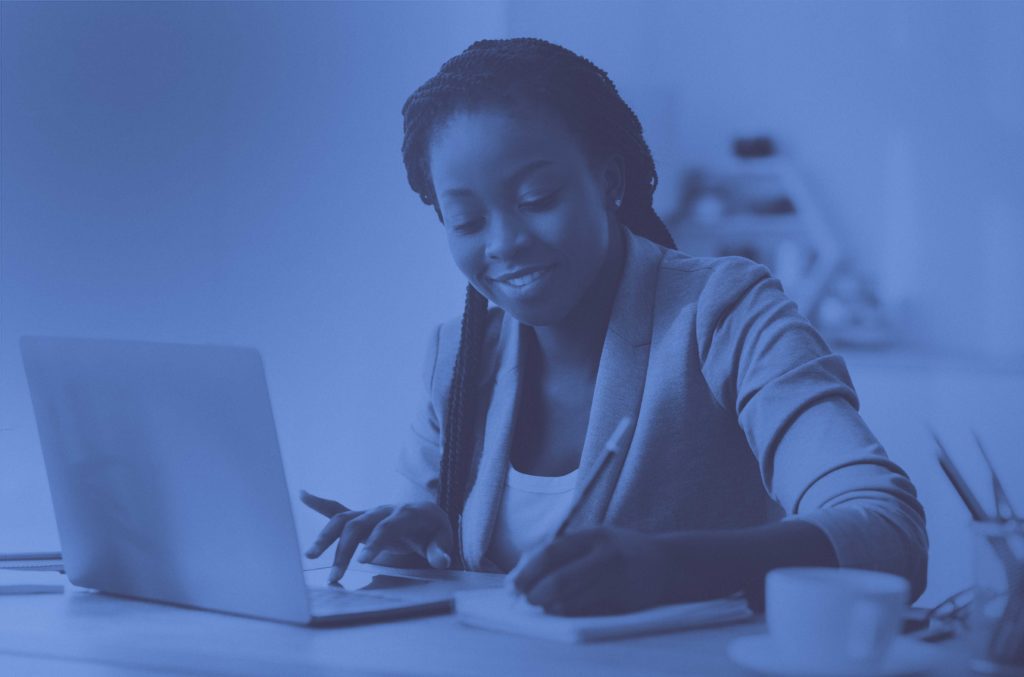 Woman writing by computer