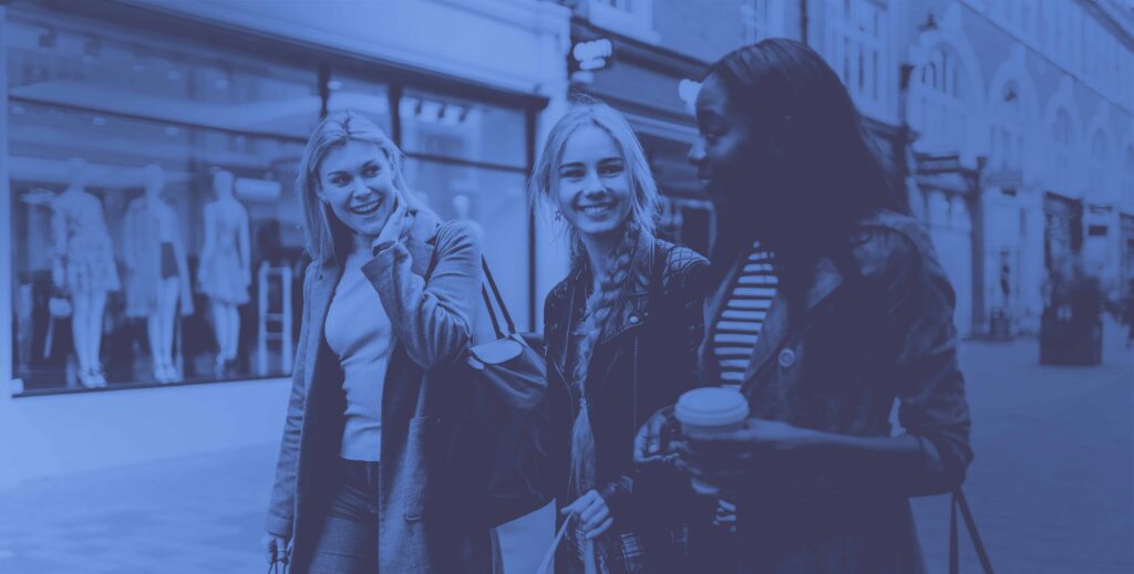 three women shopping walking in street together